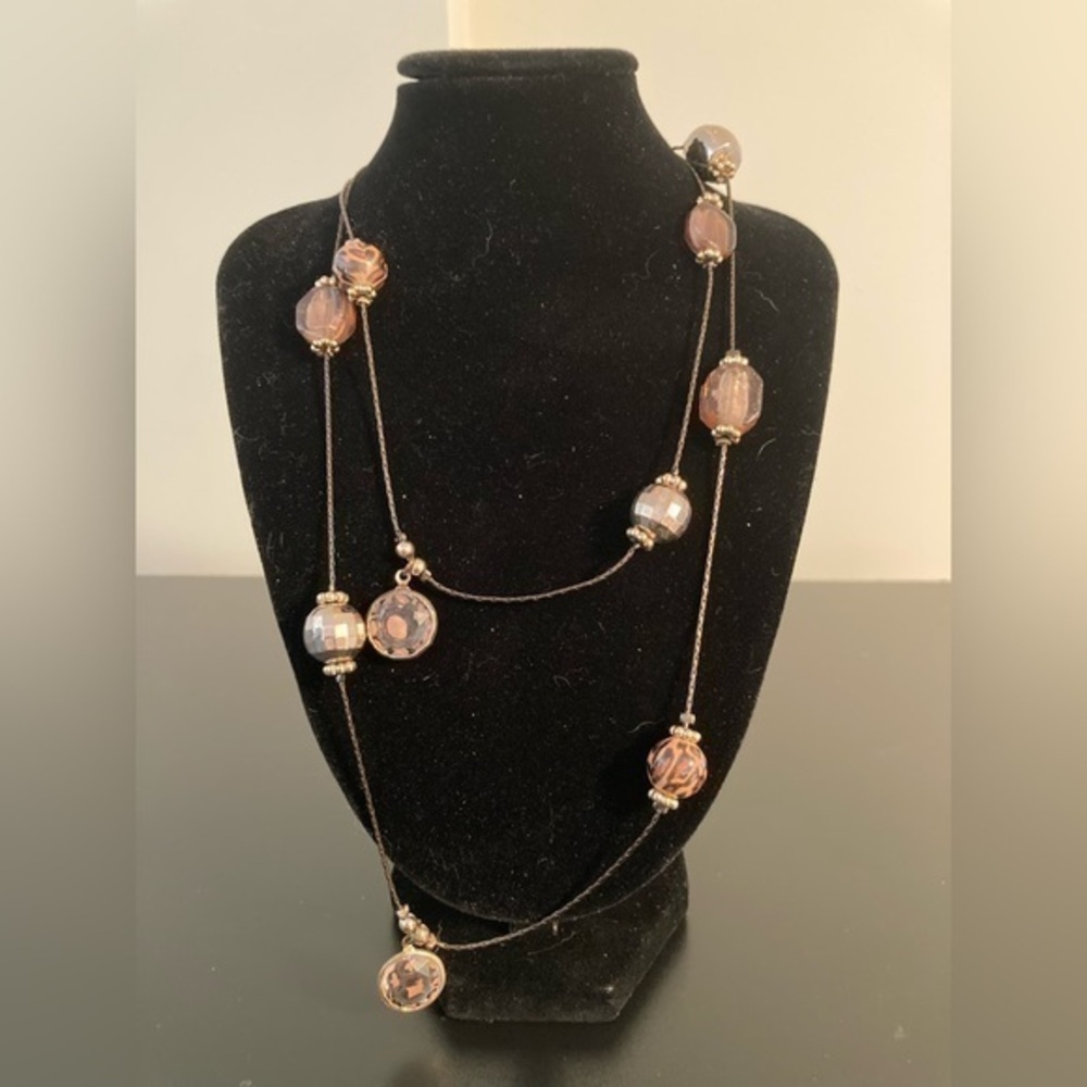 Long orange/brown beaded necklace.